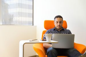Fyr sidder på en cafe med en kaffe og en computer